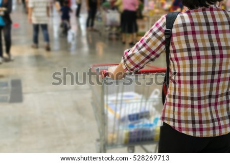 Thai woman shopping by shopping cart in Department store or shopping mall is a popular destination for walks and relaxing family in holiday.