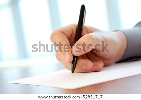 Close-up of male hand with pen making notes during conference