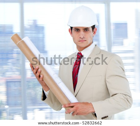 Handsome architect holding a blueprint  in the company