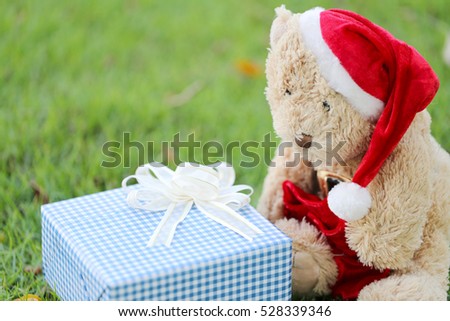 Teddy bear and gift boxes on the lawn in concept of giving gifts in Festival and Event of Christmas Day.
