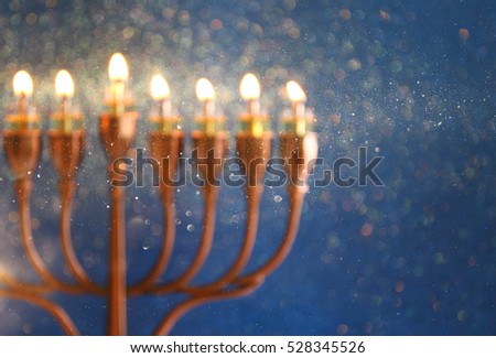 abstract and blurry image of jewish holiday Hanukkah background with menorah (traditional candelabra) and burning candles