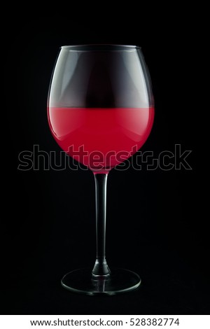 Glass of pink wine on black background