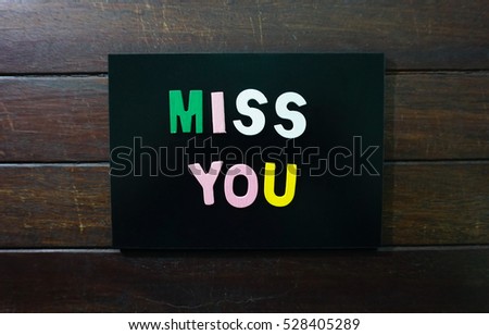 Miss You word made with block wooden letters over the wooden surface