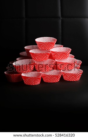 baking and eating concept, polka dots cups, paper muffin cups, cute assorted cups for cupcake and cookies colorful muffin or cupcake cups. baking paper cup. round shape. black background. 
