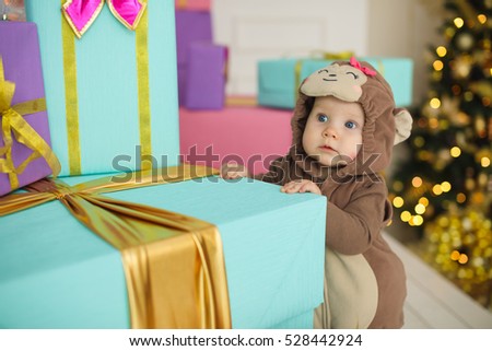 child standing among blue, azure and pink gift boxes. Pastel shades