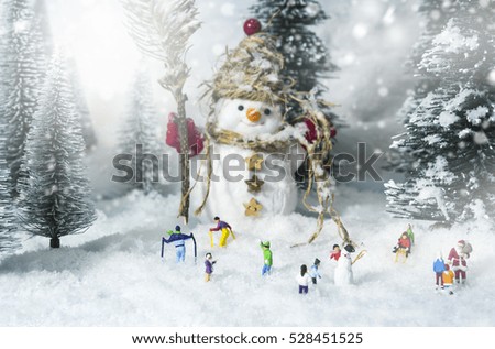 Snowman and people in pine woods during winter