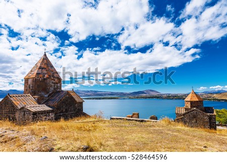 Scenic view of an old Sevanavank church in Sevan, Armenia on sunny day blue sky and fluffy clouds Royalty-Free Stock Photo #528464596