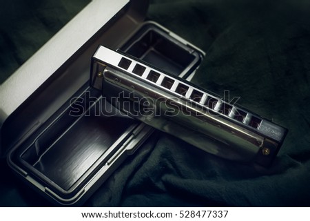 harmonicas, french harps or mouth organs. blues harp on dark background.