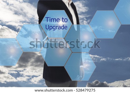 Businessman is pressing button on touch screen interface and selecting time to upgrade