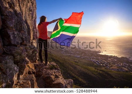 Girl holding a South African flag Royalty-Free Stock Photo #528488944