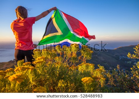 Girl holding a South African flag Royalty-Free Stock Photo #528488983