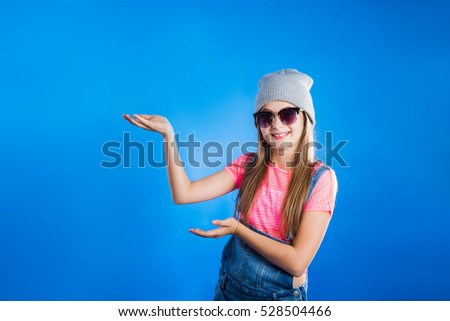 Pretty young girl  showing one side on blue background