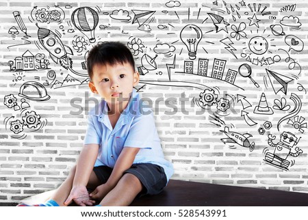 Little boy thinking many ideas with set of infographics over textured brick wall background