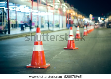 Red traffic cone on road on boken blurry abstract beautiful color light. Thailand - vintage effect style pictures