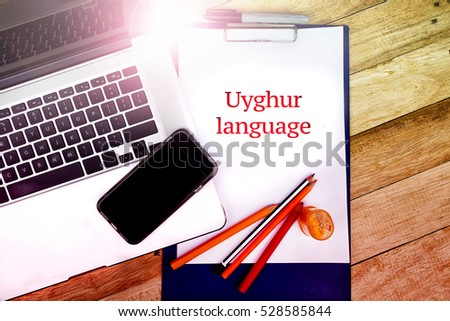  Uyghur language text at notepad in wood table.