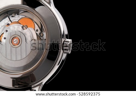 Close view of watch mechanism isolated on black background. Space for your text.