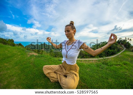 Woman Yoga - relax in nature.The woman practices yoga at dawn, there is an asana on a stone, dawn and an image of the girl, to enjoy dawn, to be happy with life, a beautiful body, ideal yoga,