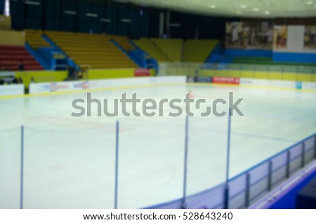 Blurred empty ice rink, hockey and skating arena indoors. Training or a performance of junior figure skating. Abstract sports background with bokeh. 