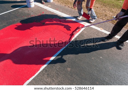 man at work : Road worker painting Red - crossing with tool
Worker painting red color on the street surface 

