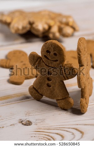 Christmas smiling  gingerbread men, men and women  on rustic wooden background