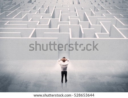 A good looking businessman with briefcase standing in front of white labirynth entrance about to make a decision concept Royalty-Free Stock Photo #528653644