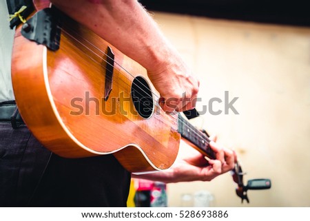 Hand playing wooden tamburitza