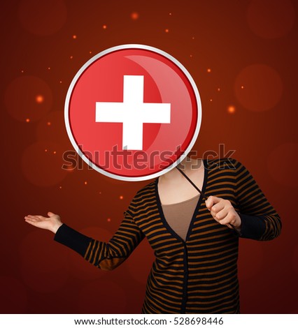 Casual young woman holding round red sign with white cross 