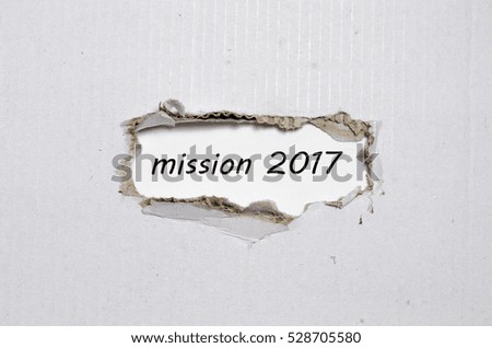 The word mission 2017 appearing behind torn paper