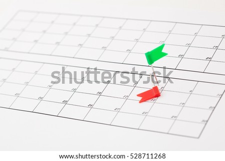 Red and green flag-pins on the calendar beside the number of date.