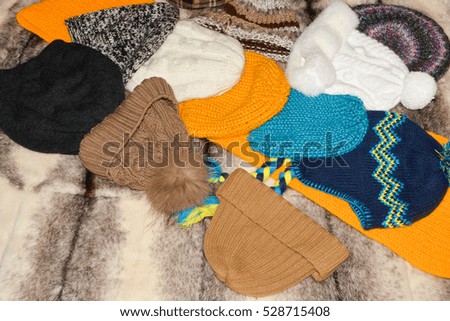 Colorful knitted hats and scarves leather gloves against the background of mink.