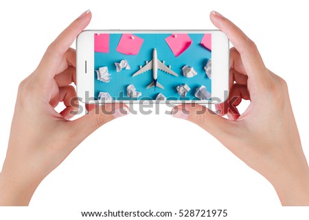Woman hand using smart phone searching Preparation for Traveling with Airplane model flying among paper clouds and pink paper noted. Travel concepts, Isolated on white background.