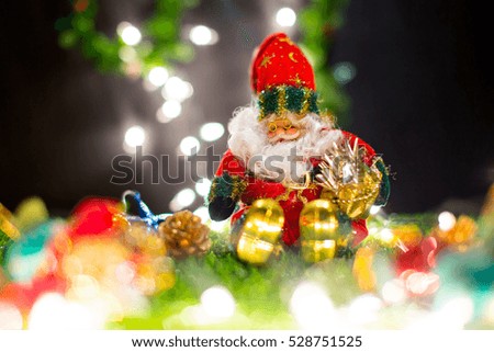 Santa claus doll in Christmas day on green grass and bokeh background. Morning sunshine day and good day.Happy time together in winter season.