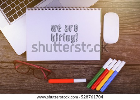 We are hiring text on wooden desk with tablet pc and keyboard
