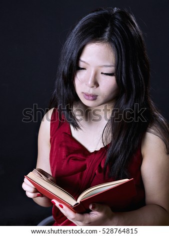 Young oriental woman reading a book
