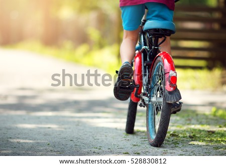 child on a bicycle at asphalt road in early morning Royalty-Free Stock Photo #528830812