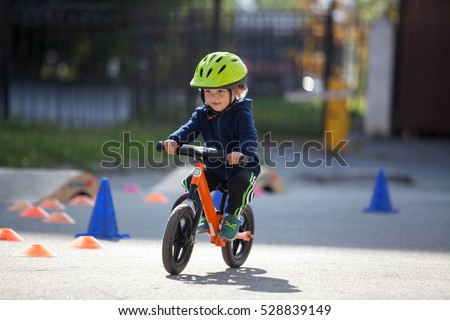 Child in helmet ride balance bike (run bike)