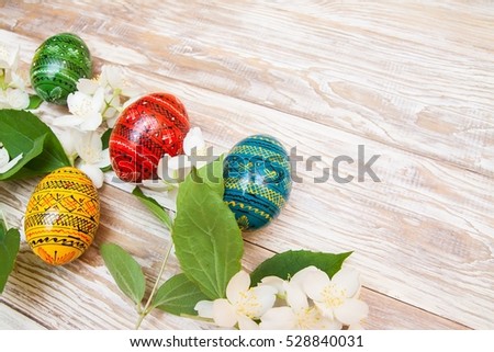 blossom flowers and wooden easter eggs. Black greeting easter card, blank on shaby wooden background.
