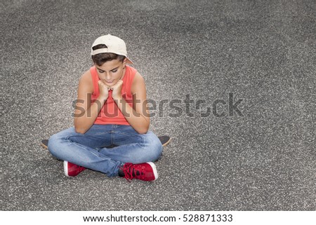 unhappy child sit on skateboard