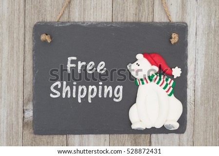 Old fashion Christmas free shipping message, A retro chalkboard with a polar bear hanging on weathered wood background with text Free Shipping