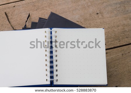 Books stack and opened pages on wooden deck background