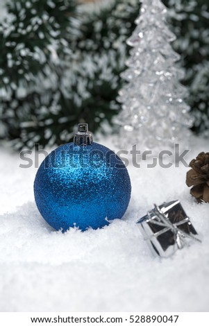 Christmas background with a blue ornament, golden gift box, Angels, berries and fir in snow on forest backround
