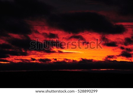 burning red evening sky with black clouds