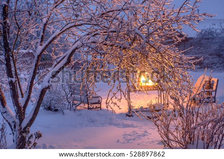 Light of bonfire through iced branches Royalty-Free Stock Photo #528897862