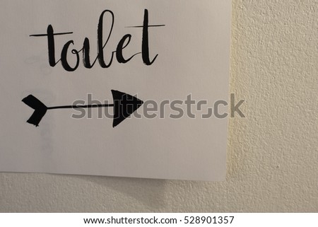 Paper toilet sign attached on the wall