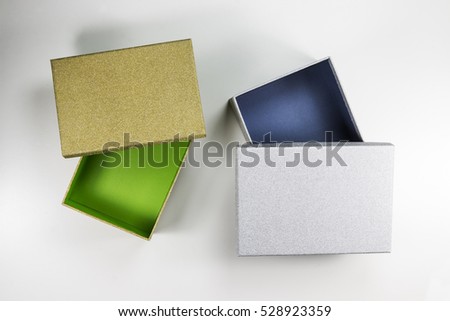 The Composition of Decorative Open Small Flat Silver Box with Blue Inside and Gold Box with Green Inside on White Background. 
Top View.
