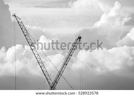 Two crane are working in high place. Black and white tone 
