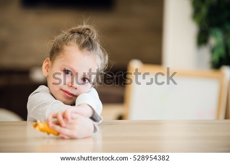 Thoughtful portrait of little girl lay on the table