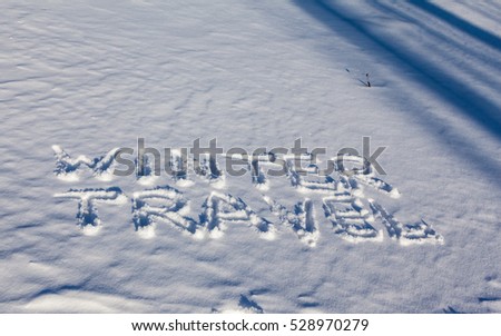 Winter travel words handwriting on the flat snow surface