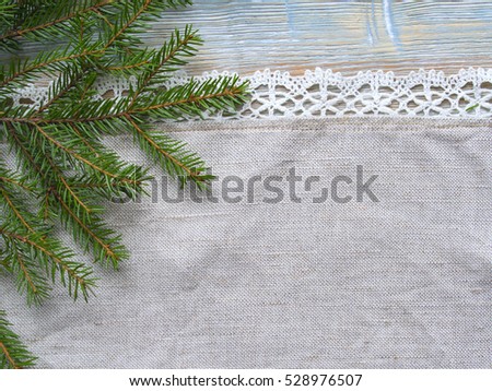 Christmas fabric with fir branch background. Wooden texture. Top view on a new year decoration.