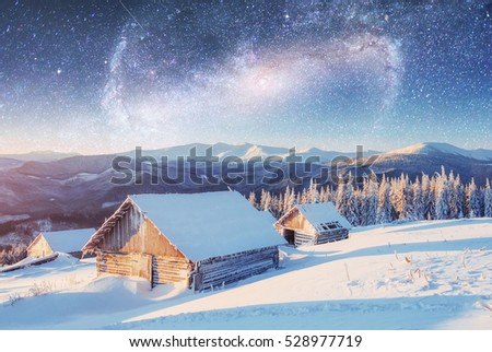 Night with stars in Christmas. Landscape of Wooden house in the mountain village in winter. Courtesy of NASA. 